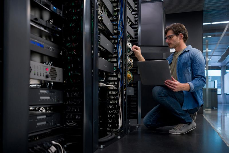 IT support technician fixing a network server at an office - technology concepts