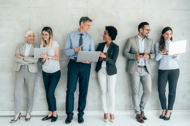Group of business people using digital devices working together in a modern office