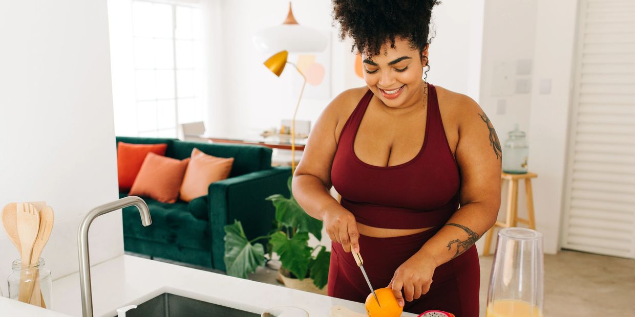 A lady cutting up fruit to make a smoothie