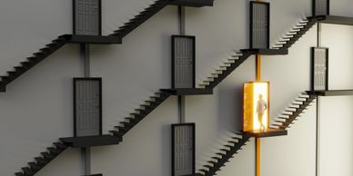 A person walks through a glowing open door among many closed doors on staircases.