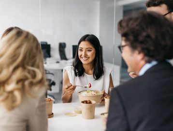 A woman eating food at an office party.