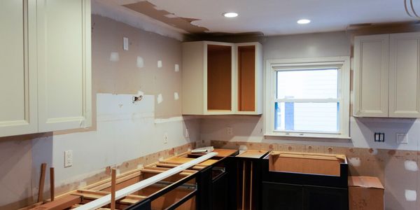 Kitchen under renovation with cabinets installed but no countertops or appliances yet.