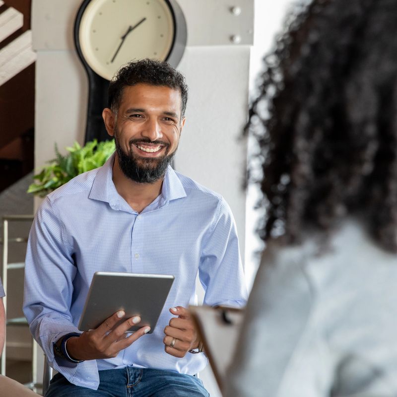 Therapist Holding Digital Tablet in group therapy