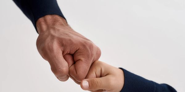 Adult and child fist bump gesture.