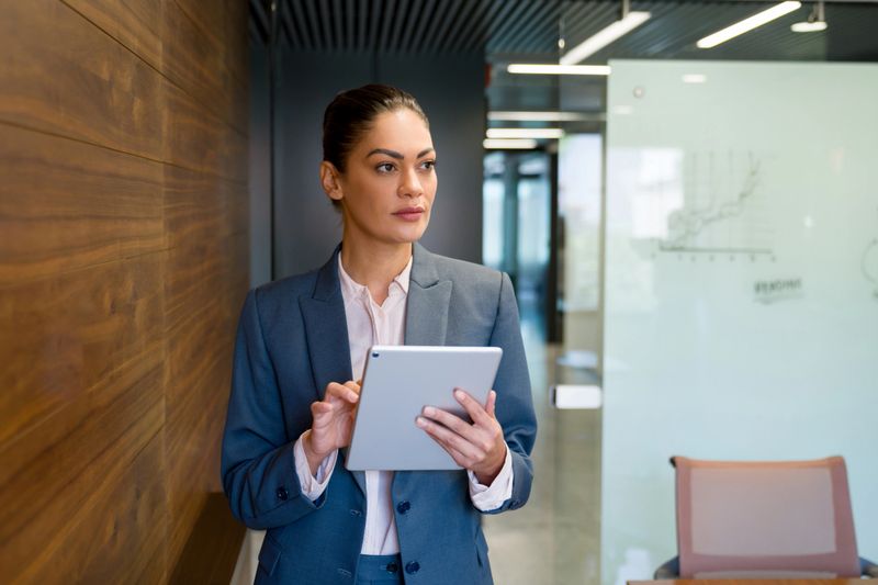 Portrait of a successful business woman working at the office using a tablet computer