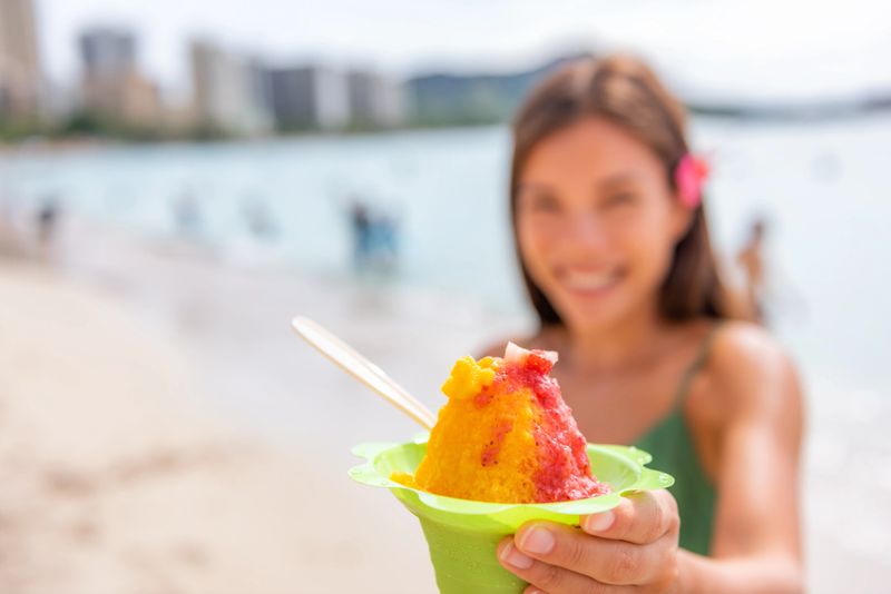 Shave Ice Hawaii Waikiki beach woman eating hawaiian shaved ice cream local food dessert in Honolulu, Oahu Island Hawaii , USA.
