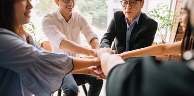 A group of professionals joining hands in teamwork.