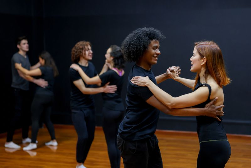 Happy Latin American couples taking dancing lessons in a dance studio