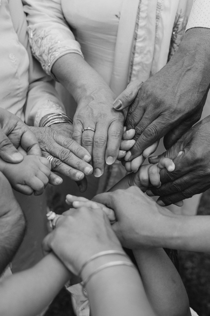 multiracial group with black african American Caucasian and Asian hands holding each other wrist in tolerance unity love and anti racism concept, black and white image. Selective focus