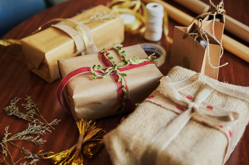 Variety of Christmas presents and in environmentally friendly wrapping paper sitting on a table during the holidays