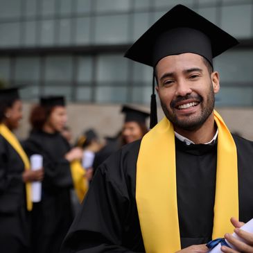Smiling graduate in cap and gown.