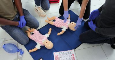 Group practicing infant CPR with mannequins.