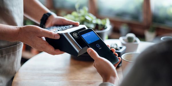 Person makes a contactless payment with a smartphone.