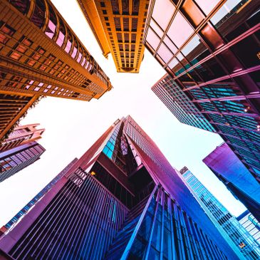 Colorful skyscrapers viewed from below against the sky.