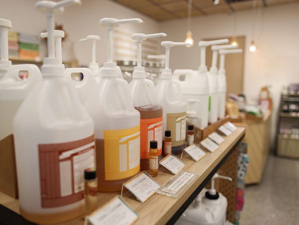 Large refillable bottles with pumps on display in a store.