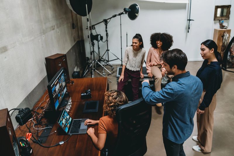 A photographer is taking a look at the pictures with models and directors.