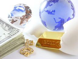 Money, diamond, gold bar, key, and a globe with eggshells symbolizing wealth and opportunity.