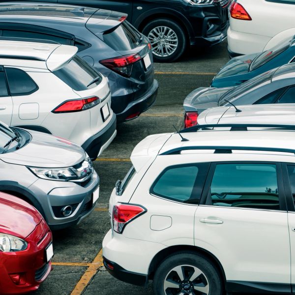 Crowded parking lot with various cars.