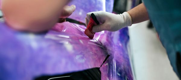 Shiny chrome car wheel on a vibrant green sports car body.