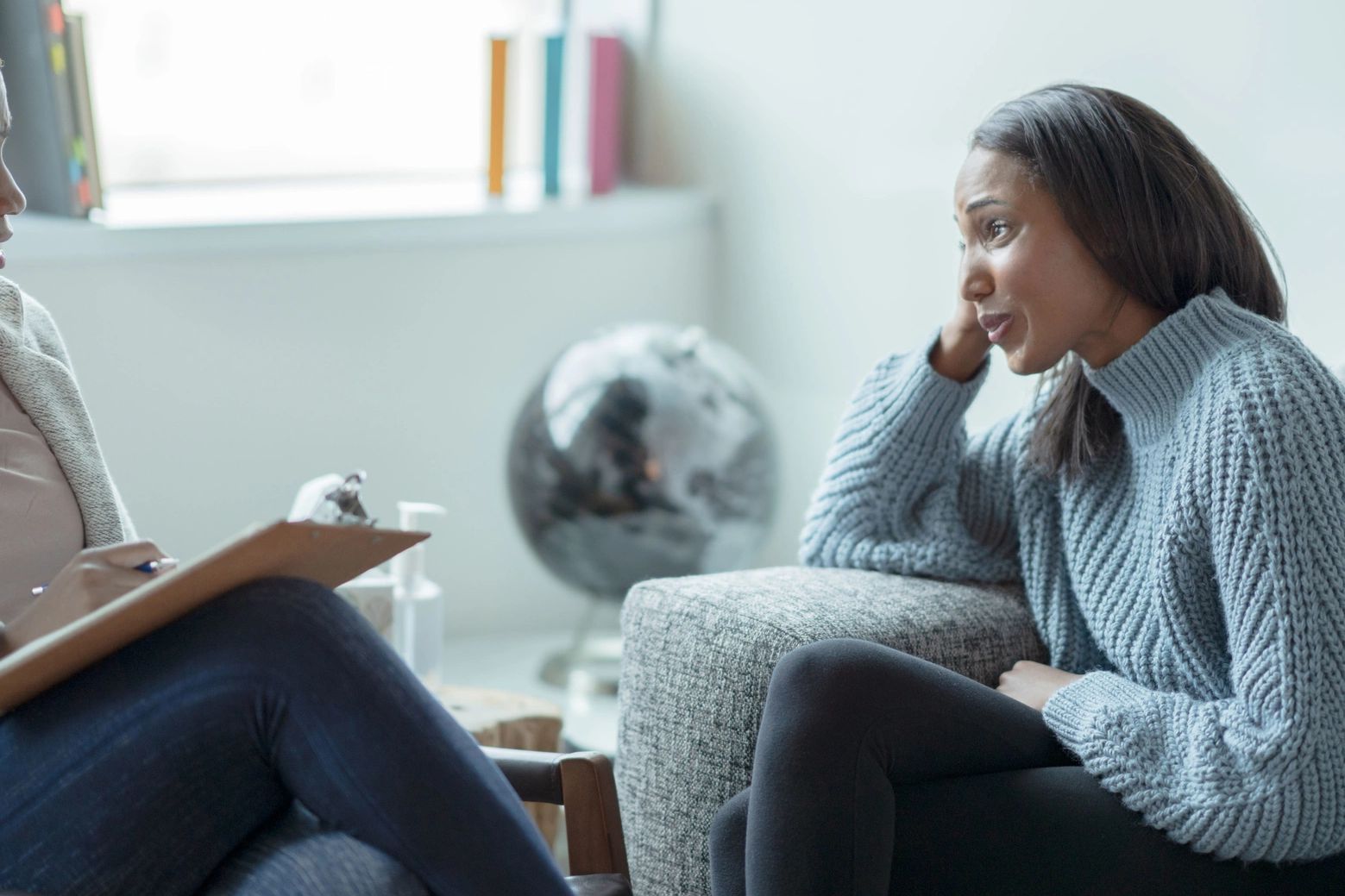 Woman sharing feelings with therapist in cozy office.