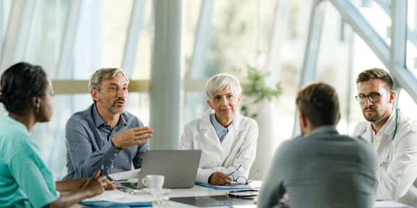 Doctors and medical professionals discussing at a meeting table.