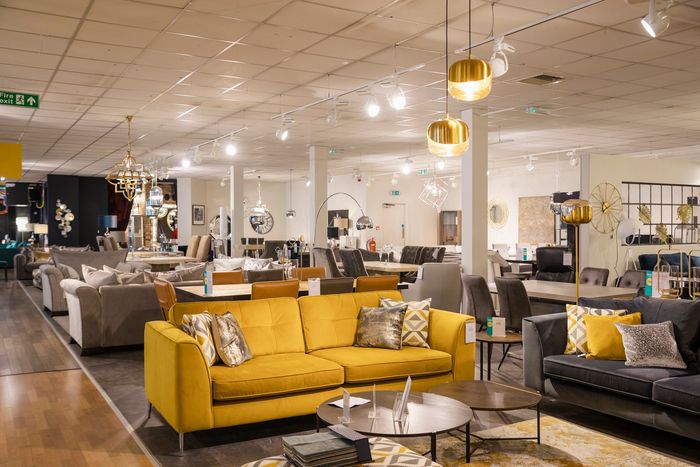 Spacious furniture showroom with modern sofas and elegant lighting.