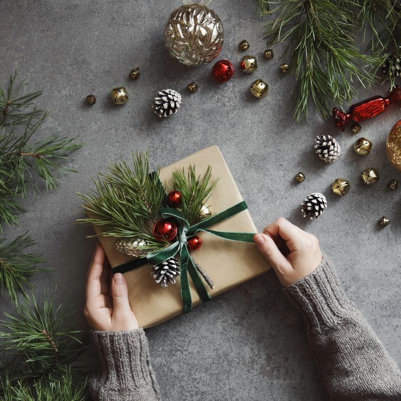 High angle view of young woman decorating Christmas present