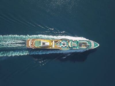 Aerial view of a cruise ship sailing through calm waters.