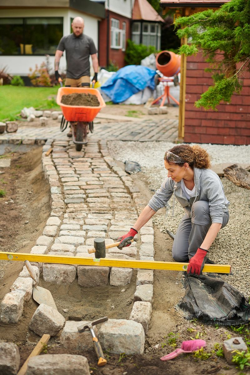 homeowner installing a cobble path