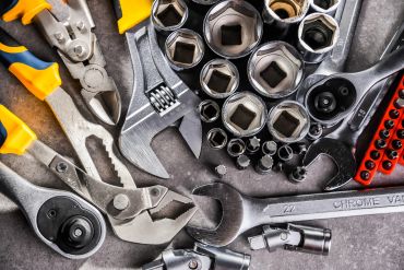 A collection of various hand tools including wrenches, pliers, and socket sets.