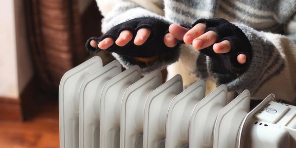 Person warming hands near a heater.