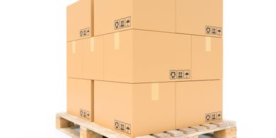 Stacked cardboard boxes on a wooden pallet isolated on white.