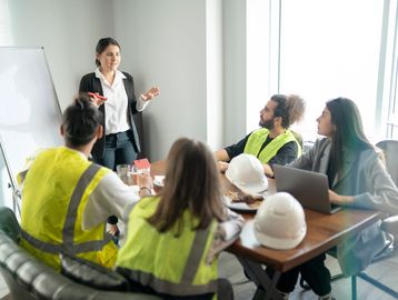 Team meeting with safety vests and helmets.