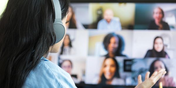 Person participating in a video conference call wearing headphones.