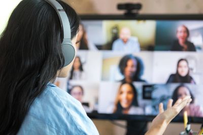 Person attending a virtual meeting with headphones.