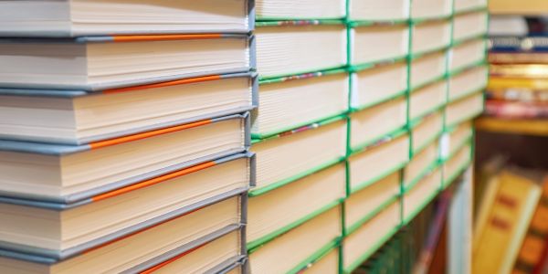 Stacks of hardcover books arranged closely on shelves.