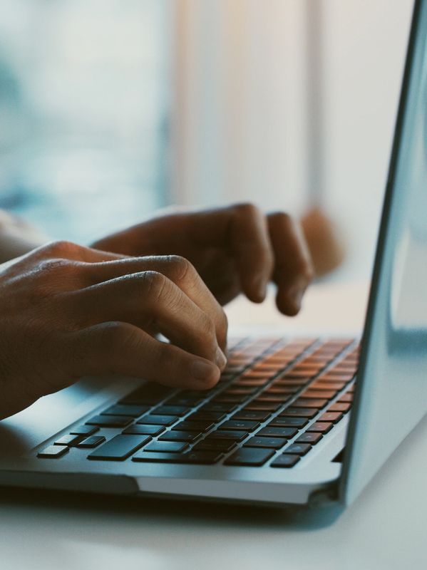 Person typing on a laptop keyboard.