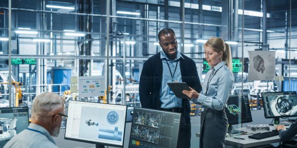 Engineers discussing a project in a high-tech industrial workspace.