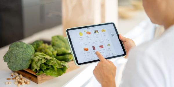 Person shopping for fresh produce online using a tablet.