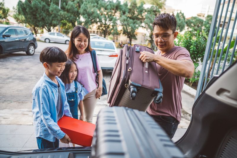 Happy Asian family Packing Car Ready For Chinese New Year Eve. Family prepare and arrange luggage and packing ready to traveling outdoors journey.