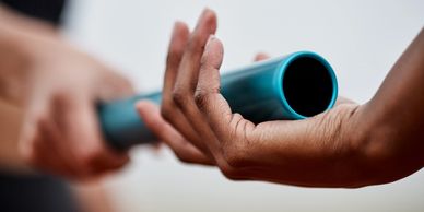 Two hands passing a relay batton