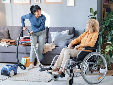 Personal support worker in Kingston, Ontario providing light housekeeping and home care while assisting a senior in a wheelchair.