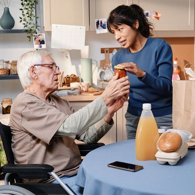 Personal support worker in Kingston, Ontario assisting a senior in a wheelchair with groceries and home care support.