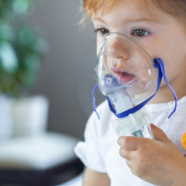 Child using a nebulizer mask for breathing treatment.