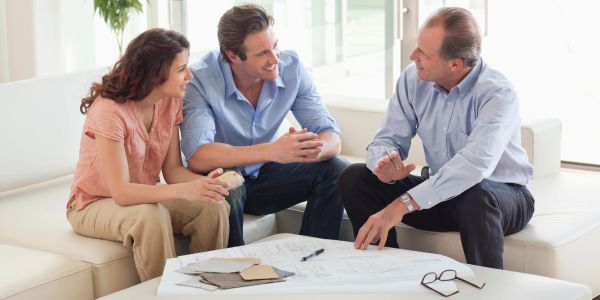 Couple discussing plans with a consultant indoors.