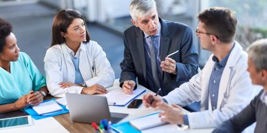 Medical professionals in a discussion around a table.