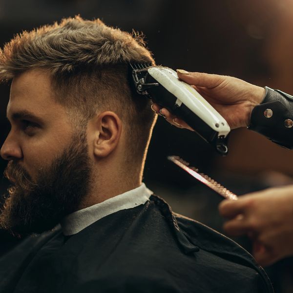 Man getting a haircut with clippers at a barbershop.