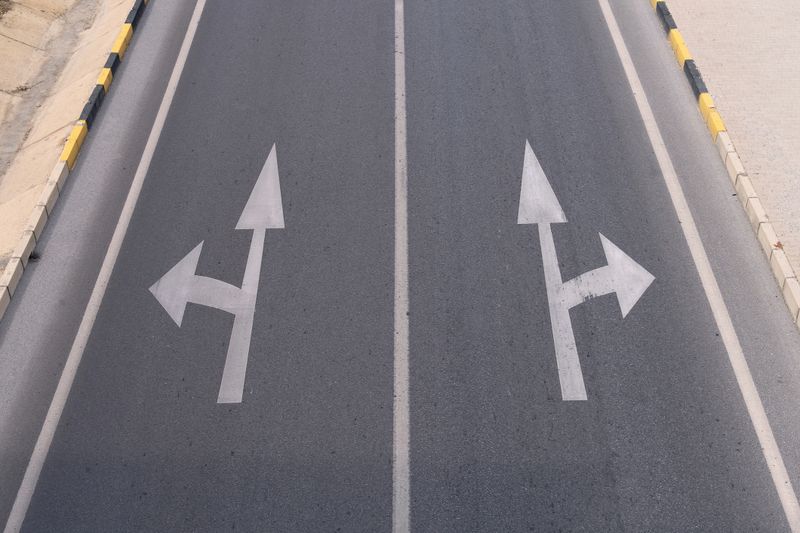 View from the top to the direction arrows on the asphalt road.