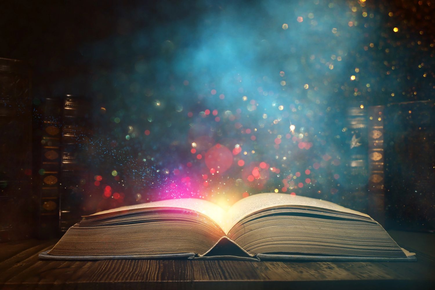 An open book emits magical colorful light and sparkles in a dimly lit room.