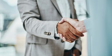 Two people shaking hands in a professional setting.